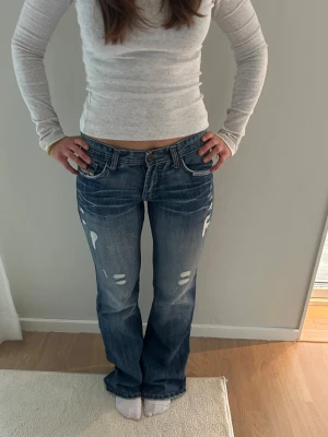 Jeans med slitningar - Låga jeans med slitningar i storlek XXS-XS. Midja: 35x2 cm innerben: 80 cm 