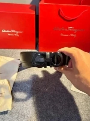 Svart skärp från Salvatore Ferragamo - Snyggt svart skärp från Salvatore Ferragamo med ikoniskt dubbel-Gancio-spänne i svart metall. Skärpet har en stilren och modern look, perfekt för att lyfta vilken outfit som helst. Kommer med originalpåse och presentförpackning.