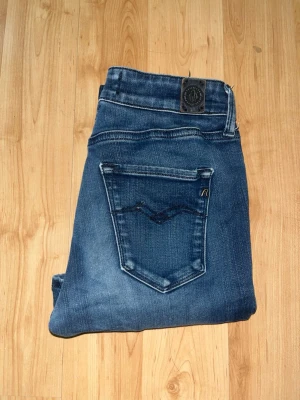 Replay Hyperflex jeans  - Säljer ett par Replay Hyperflex jeans i mörkblå tvätt med snygga slitningar. Modellen är skinny fit. Midja 30cm, längd 88cm. JAG SKICKAR EJ FLER BILDER NÄR JAG BÄR JEANSEN! för bättre inblick i passformen rekommenderar jag att googla på modellnamnet. För storleksguide kolla måtten noggrant då jeansen alltid kan vara uppsydda heller krympta och jag ej tar emot returer :) s6,1