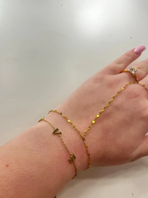 Guldarmband från Edblad  - Snyggt guldarmband med tunna länkar och bokstäverna L, O, V, E samt ett litet hjärta. Armbandet har en modern och trendig look, perfekt för dig som gillar personliga detaljer. Passar till många olika stilar och är lätt att matcha med andra smycken.