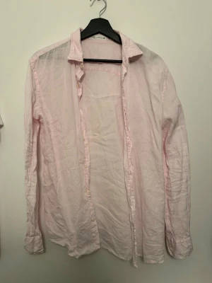 Ljusrosa skjorta från Zara - Säljer en ljusrosa skjorta från Zara i tunn bomull. Skjortan har klassisk krage, långa ärmar och knappar framtill. Perfekt för en avslappnad och stilren look