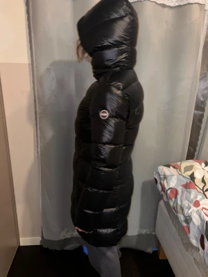 Svart lång dunjacka från colmar - .Lyxig svart Colmar dunjacka i lång modell, storlek 44 (upplevs som 42). Väldigt varm, stilren och i toppskick. Använd fåtal gånger. Perfekt för kalla dagar. Kvitto finns. 