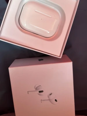 Apple AirPods Pro med laddningsetui - Säljer ett par vita Apple AirPods Pro med trådlöst laddningsetui. Snygg och stilren design i blank plast, perfekt för dig som vill ha grymt ljud och brusreducering. Kommer i originalförpackning. Min brors gamla han har använt de en gång.