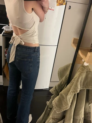 Blå utsvängda jeans med lågmidja - Säljer ett par klassiska blå jeans med utsvänga ben och låg midja. Jeansen har fem fickor och stängs med dragkedja och knapp. Snygg tvätt och tidlös modell som passar till det mesta. Perfekta för dig som gillar en enkel och clean look.