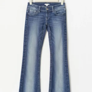 Low waist jeans Gina tricot  - Snygga blå bootcut jeans med slitningar och broderad bakficka med paljettdetaljer. Klassisk femficksmodell och normalhög midja. Jeansen har en cool tvätt och är perfekta för en avslappnad men trendig look.