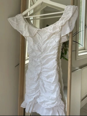 POPULÄR SLUTSÅLD ZARA klänning  - Säljer en vit kortklänning med  volangdetaljer. Klänningen har en offshoulder-modell , använd 1 gång perfekt som student klänning ! Ifrån ZARA slutsåld 