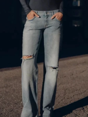 Ljusblå ripped straight jeans - Snygga ljusblå jeans med raka ben och slitningar vid knäna. Perfekta för en avslappnad och trendig look.