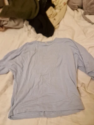 Ljusblå basic t-shirt XS - En enkel och stilren ljusblå t-shirt i storlek XS. T-shirten har rund halsringning och korta ärmar, perfekt för en avslappnad look. Tillverkad i mjukt bomullsmaterial som känns skönt mot huden.