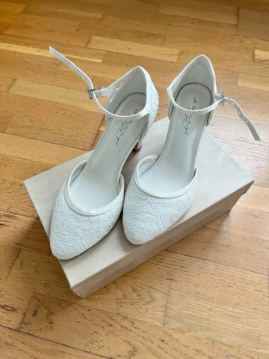Bröllopsskor - Säljer mina vackra bröllopsskor då jag valde ett annat par till den stora dagen. Skorna är endast använda hemma för att träna att gå i dem och är alltså i nyskick – inga märken eller slitage.  Nypris 1800 kr, säljes för 1200 kr. Tillbehör ingår. 