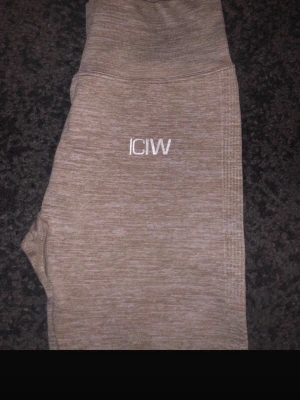  träningstights från ICANIWILL -  träningstights från ICANIWILL med hög midja och ribbade detaljer längs benen. Tillverkade i ett stretchigt material som passar perfekt för gymmet eller löpning. Diskret logga framtill. Supersköna och stilrena tights för alla träningspass.