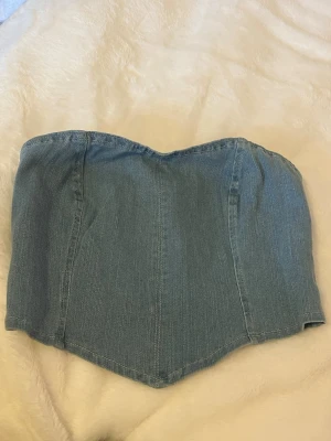 Blå denim tubtopp  - Blå tubtopp i denim med markerad midja och dragkedja bak