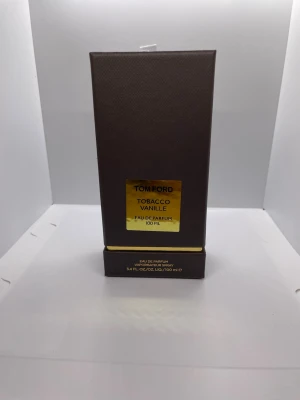 Tom Ford Tobacco Vanille EdP 100 ml - Lyxig parfym från Tom Ford, Tobacco Vanille Eau de Parfum i 100 ml. Förpackningen är elegant och mörkbrun med gulddetaljer och rektangulär form. Passar dig som gillar exklusiva och varma dofter med inslag av tobak och vanilj.
