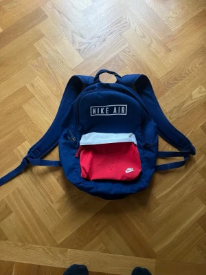 Backpack - Nike air max backpack Håller 22L En liten ficka där fram och på sidan En står ficka med hållare för dator, block, etc En vattenflask hållare