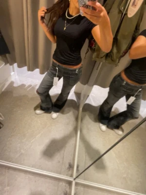 Grå bootcut jeans med låg midja - Säljer ett par grå bootcut jeans med låg midja och klassisk femficksdesign. Jeansen har en lätt tvättad look och sitter snyggt över höfterna. Använd fåtal gånger. De är slutsålda.har sytt upp de men kan ta bort det om ni skulle vilja 