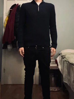 Jack and jones PREMIUM!!! quarter zip - Säljer en svart ribbstickad tröja med halvzip och hög krage. Tröjan har långa ärmar och en stilren, minimalistisk look som passar perfekt till jeans eller chinos. Materialet känns mjukt och stretchigt, vilket gör den bekväm att bära hela dagen.