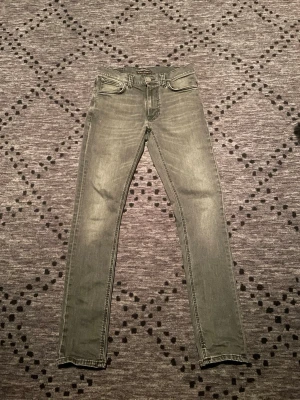 Nudie jeans - Helt nya Nudie jeans köpta i Nudie butiken i Göteborg för 1600kr. Påse går att få med. Jeansen är i nyskick och är i en riktigt snygg tvätt samt grå färg. Priset är inte hugget i sten så vid snabb förhandling kan priset sänkas!