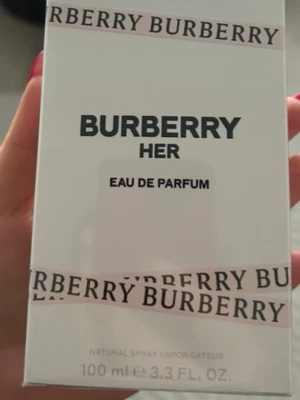 Burberry Her Eau de Parfum 100 ml - Burberry Her Eau de Parfum i en elegant, genomskinlig glasflaska med ljusrosa lock och gulddetalj. Flaskan rymmer 100 ml och har en stilren design med Burberry-loggan ingraverad i glaset. Doften är modern och feminin, perfekt för dig som gillar lyxiga parfymer.