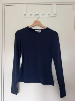 Mörkblå figursydd topp Pull&Bear - En stilren mörkblå långärmad topp från Pull&Bear. Modellen är figurnära med rund halsringning och tillverkad i ett mjukt, stretchigt material.