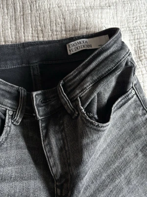 Grå raka jeans från Vero Moda - Säljer ett par grå jeans från Vero Moda med rak passform och klassisk femficksdesign. Jeansen har medelhög midja och är tillverkade i ett mjukt denimtyg.