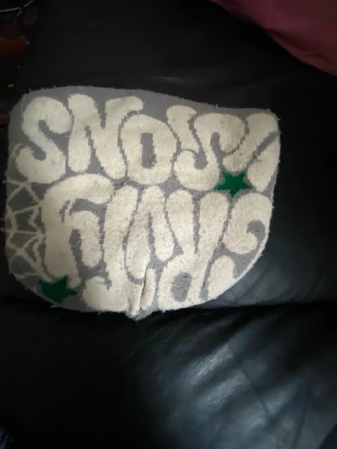 Grå mössa med spindelnät och text - 1