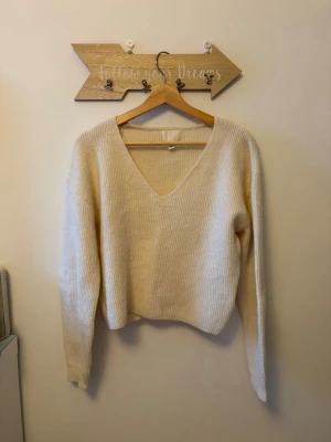 Beige stickad v-ringad tröja h&m - Mysig krämvit stickad tröja med v-ringning och långa ärmar. Tröjan har en enkel, ribbad struktur och en något loose passform. Passar till allt och är superenkel att styla.