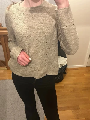 Beige stickad tröja från ONLY - Stickad tröja i beige från ONLY med rund halsringning och diskret hålmönster. Superfin och passar till allt!
