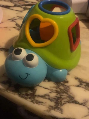 Färgglad sköldpaddspussel leksak - Rolig sköldpaddsleksak i plast med olika färgglada former att stoppa i rätt hål. Skalet har öppningar i form av hjärta, cirkel, fyrkant och stjärna. Perfekt för att träna formigenkänning och motorik. Kommer med flera matchande klossar i olika färger.