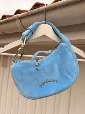 Ljusblå axelväska från Juicy Couture - 💎Juicy Couture Blossom Small Hobo💎 Ljusblå med silverfärgade detaljer. Både kort och lång axelrem som går att ta av ✨ Söt, trendig och perfekt för en  bekväm lyxig stil! 🔶 Använd endast en gång 🔶Perfekt för dig som gillar Y2K-stil och vill sticka ut. 🦋 