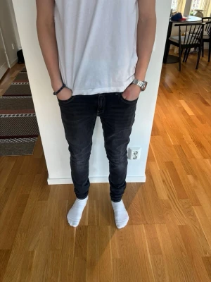 Svarta slim fit jeans från G-Star L29 W34 - Säljer ett par svarta slim fit jeans med klassisk femficksdesign och smal passform. Jeansen har en lätt tvättad look och sitter tajt längs benen. Perfekta för dig som gillar en modern och stilren stil. Bara att hojta till vid fundering!! Jeansen är korta för sin storlek!