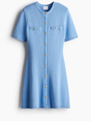 Blå stickad kortklänning med knappar - Supersöt ljusblå stickad kortklänning med guldknappar framtill och två dekorativa bröstfickor. Klänningen har korta ärmar och rund halsringning, perfekt för en fräsch och trendig look.