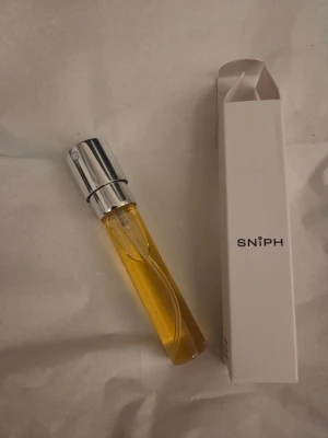 Sniph parfym - 003 SIA - Ny endast testad enngång, ca 8ml edp. Noter: Mandarin – En söt citrusnot med inslag av honung.  Jasmin – En floral not med många sidor. I Sia är den mjuk och indolisk.  Socker – En doftnot som vi alla känner väl! Ger Sia en kanderad grundton och gör doften ungdomligt tilltalande.