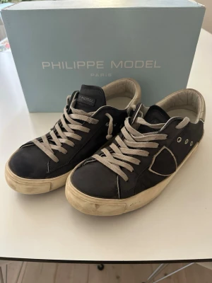 Philippe Model - mörkblå - Säljer min sons Philippe Model, marinblå. Stl 39 Inköpta på Farfetch Tillgänglig på Facetime om du vill titta på skorna på distans. Endast anvönda en säsong. Originalkartong medföljer.   Fint skick, inga nötningar i häl.