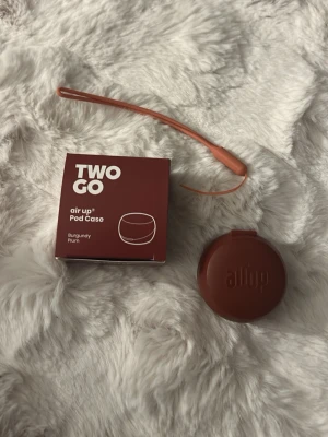 air up Pod Case Burgundy Plum - Säljer ett runt pod-fodral från air up i färgen Burgundy Plum. Fodralet är gjort i silikon och har en matchande handledsrem. Perfekt för att förvara och skydda dina pods på ett snyggt och smidigt sätt. Aldrig använd