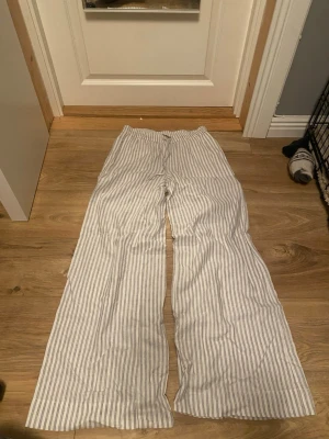 Randiga linnebyxor från bikbok - Snygga och luftiga linnebyxor från bikbok i storlek XS. Byxorna har en rak, lös passform med låg midja. Perfekta för en chill och avslappnad stil under varma dagar! Endast provade då de tyvärr inte var min stil💗