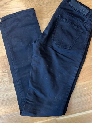 Svarta raka jeans tiger of Sweden - Säljer ett par svarta jeans med rak passform och klassiska bakfickor. Jeansen har en enkel design utan synliga loggor och är tillverkade i ett mjukt denimtyg. Perfekta för dig som gillar en clean och stilren look. Tiger of Sweden