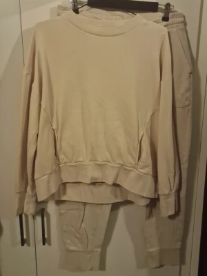 Ljusrosa mjukisset med sweatshirt och byxor - Säljer ett ljusrosa mjukisset med oversized sweatshirt och matchande byxor. Tröjan har rund halsringning och breda muddar vid ärmar och nederkant. Byxorna har resår i midjan, dragsko och stora fickor framtill. Setet är gjort i mjukt bomullsliknande material.