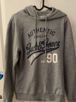 Grå hoodie från Jack & Jones - Snygg grå hoodie från Jack & Jones                       Perfekt för en avslappnad och stilren look. Priset är inte hugget i sten 🪨!