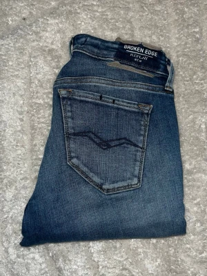 Repaly jeans  - Snygga Repaly jeans med fejk hål och slitningar. Midja 34cm, längd 95cm. JAG SKICKAR EJ FLER BILDER NÄR JAG BÄR JEANSEN! för bättre inblick i passformen rekommenderar jag att googla på modellnamnet. För storleksguide kolla måtten noggrant då jeansen alltid kan vara uppsydda heller krympta och jag ej tar emot returer :) s6,5