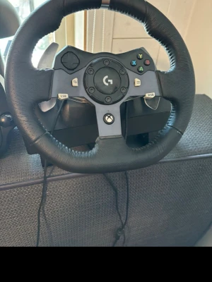 Logitech G920 ratt för Xbox och PC - Säljer en Logitech G920 racingratt med svart konstläder och metall, designad för Xbox och PC. Ratten har klassiska Xbox-knappar, paddlar i metall och en robust konstruktion som ger realistisk racingkänsla. Perfekt för dig som vill ta racing till nästa nivå. Pedaler med gas, broms och koppling, och växelspak för att få en ännu mer realistiskt känsla
