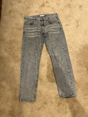 Grå tvättade jeans från Woodbird - Säljer ett par grå tvättade jeans från Woodbird i modellen ourhanic i storlek 30/30. Modelle har raka ben och klassisk femficksmodell. Jeansen har en snygg vintagekänsla och är tillverkade i bomull. Pris kan diskuteras!! Vid minsta fundering är det bara att höra av sig!