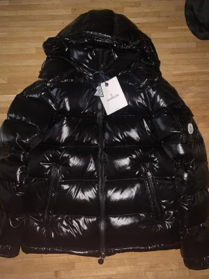 Monclear Maya  - Helt ny moncler jacka, riktigt snygg och varm. Perfekt för vårat kalla väder. Storleken är M alla tags är med och som ni ser förs man direkt till monclers hemsida om man har mobilen vid märket. Fraktar alltid inom 12 timmar, pris är 1699 men vid snabb affär kan jag vara väldigt flexibel. Hör gärna av er😄