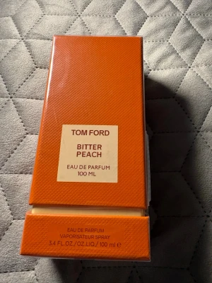 Tom Ford Bitter Peach & Xerjoff Opera - Två exklusiva parfymer: Tom Ford Bitter Peach Eau de Parfum 100 ml i en snygg orange förpackning och Xerjoff Opera Eau de Parfum 100 ml i elegant vit och vinröd kartong. Båda är lyxiga dofter som sticker ut och kommer i originalförpackning.