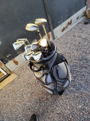 Golfbag med ett helt set golfklubbor - Golfbag från Big Max i grått och svart med flera stora och små fack samt separata hål för klubbor. Setet av klubbor består av järn 4-P, 56 grader, putter och trä 4 och 5