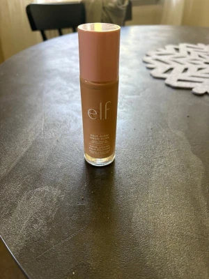 e.l.f. Halo Glow Foundation Fair/Light - Flytande foundation från e.l.f. i nyansen Shade 2 Fair/Light. Kommer i en glasflaska med rosa lock och har en naturlig glow-finish. Perfekt för dig som vill ha en lätt och fräsch bas. Enkel att applicera och ger ett jämnt resultat. Köpte fel färg aldrig använt 