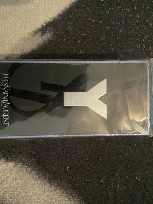 Yves Saint Laurent Y Eau de Toilette - Säljer en parfym från Yves Saint Laurent, Y Eau de Toilette. Förpackningen är svart med en stor silverfärgad Y-logga och tydlig YSL-text på sidan. Modern och stilren design som passar perfekt för dig som gillar exklusiva dofter.