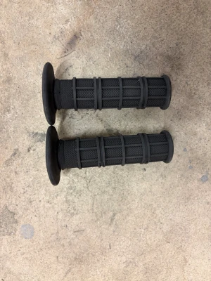 Svarta handtag till cykel eller moped - Säljer ett par svarta handtag i gummi med räfflat grepp och förstärkta kanter. Passar till cykel, moped eller liknande styre. Handtagen har en klassisk cylindrisk form och är designade för bra grepp och komfort.