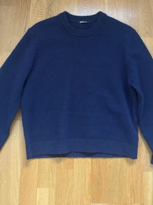 Mörkblå stickad tröja från Gina Tricot - En stilren mörkblå stickad tröja från Gina Tricot. Enkel att matcha med jeans eller kjol. Klassisk modell med lång ärm och mjukt material.