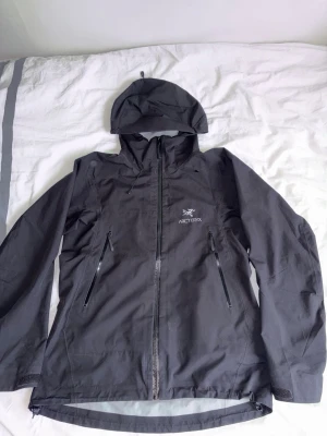 Svart vindjacka från Arc'teryx - Arc'teryx jacka vattentät Gore-Tex-jacka i bra skick. Säljs då den inte används. Storlek M inget kvitto 