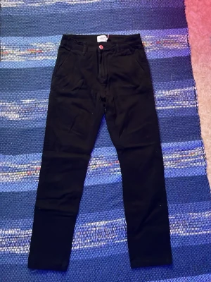 Svarta raka jeans från 157 - Säljer ett par svarta jeans från 157 med rak passform och klassisk femficksdesign. Jeansen har knappgylf och med lite stretch för extra komfort. Perfekta till en avslappnad stil.