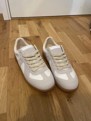 Vita och beige Maison Margiela GATS - Snygga sneakers i vitt och beige. De är använda lite, och det finns inga fläckar,hål eller missfärgningar. Djur och rökfritt hem. Storlek 41